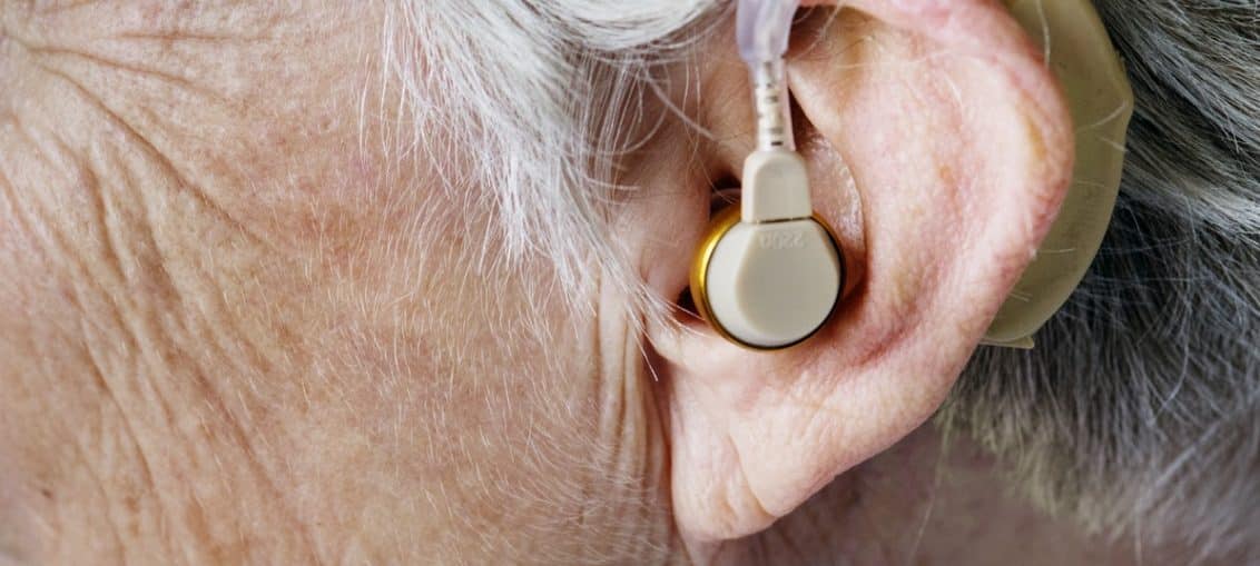 Personne âgée souffrant de surdité équipée d'un appareil auditif pour mieux entendre